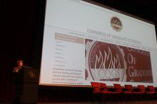 person standing behind a podium onstage during a presentation