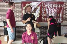 people smiling and posing in front of Congress of Graduate Students banner