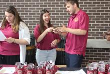 students talking behind a table of COGS merchandise