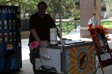 person standing behind booth serving food