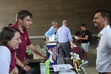 student and staff person laughing as they talk at a table