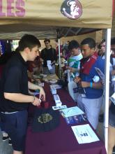 students talking to a staff person at a table