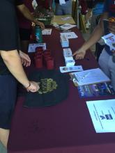 students talking to a staff person at a table