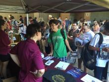 students talking to a worker at a table