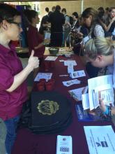 students talking with staff at a table