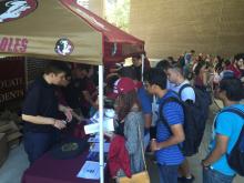 students talking to a staff person at a table