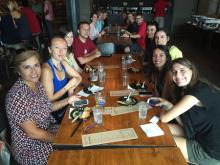 students smiling and posing at a table for eating