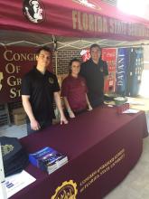 students standing behind a table at an outdoor event