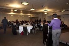 people sitting at tables watching a presentation