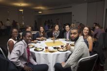 people posing for a picture while sitting around a table