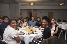 people posing for a picture while sitting around a table