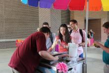students waiting to be served food from a booth