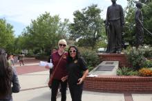 students posing in front of the Integration statue