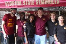 COGS students smiling and posing under an awning