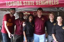 COGS students smiling and posing under an awning