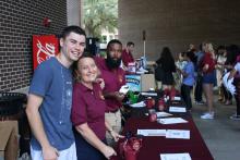 people smiling and posing near a table