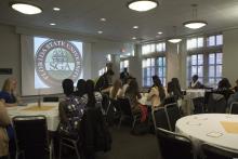 people sitting at tables watching a presentation