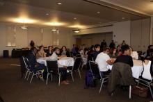 people sitting at tables watching a presentation