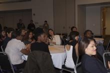 people sitting at tables watching a presentation