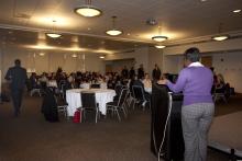 people sitting at tables watching a presentation