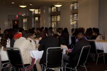 people sitting at tables watching a presentation