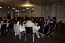 people sitting at tables watching a presentation
