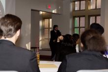 people sitting at tables watching a presentation