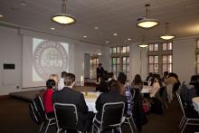 people sitting at tables watching a presentation