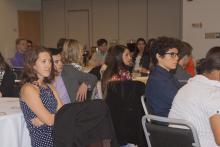 people sitting at tables watching a presentation