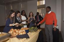 people lining up to select food from a buffet