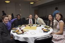 people posing for a picture while sitting around a table