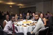 people posing for a picture while sitting around a table