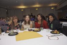 people posing for a picture while sitting around a table