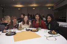 people posing for a picture while sitting around a table