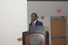 person standing behind a podium speaking during a presentation