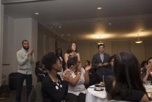 three people speaking in the front of a room