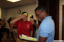 man looking up as a sticky note is placed on his forehead