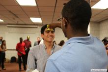 man looking up as a sticky note is placed on his forehead