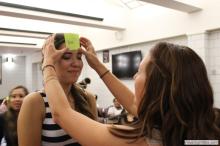 woman looking up as a sticky note is placed on her forehead