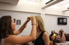 woman looking up as a sticky note is placed on her forehead