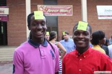 two men posing together with sticky notes on their forehead