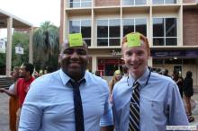 two men posing together with sticky notes on their forehead