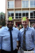 two men posing together with sticky notes on their forehead
